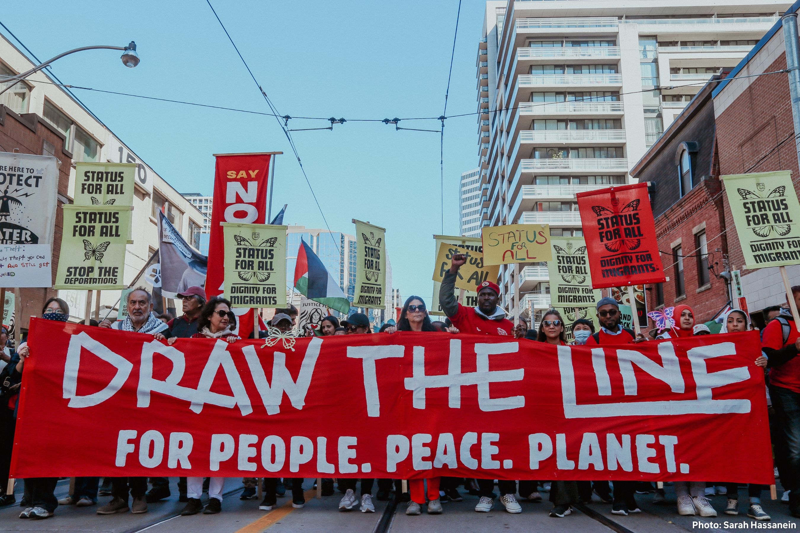 Climate protest with people holding signs including 'NO MORE FOSSILS' and 'FUND CLIMATE'