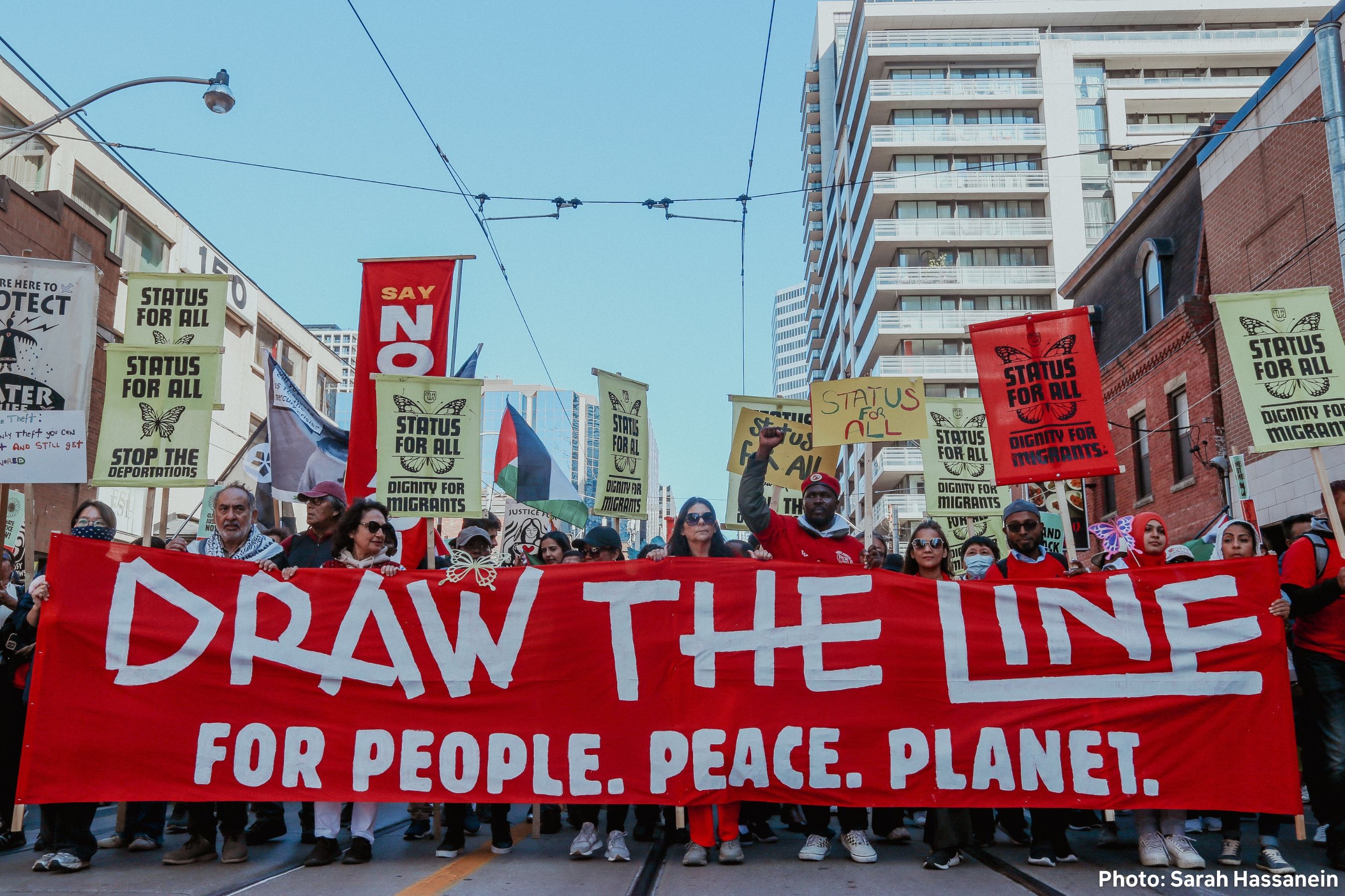 Climate protest with people holding signs including 'NO MORE FOSSILS' and 'FUND CLIMATE'